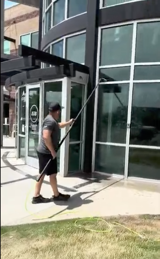 Legend Cleaning technician using a water-fed pole on a commercial storefront in Utah