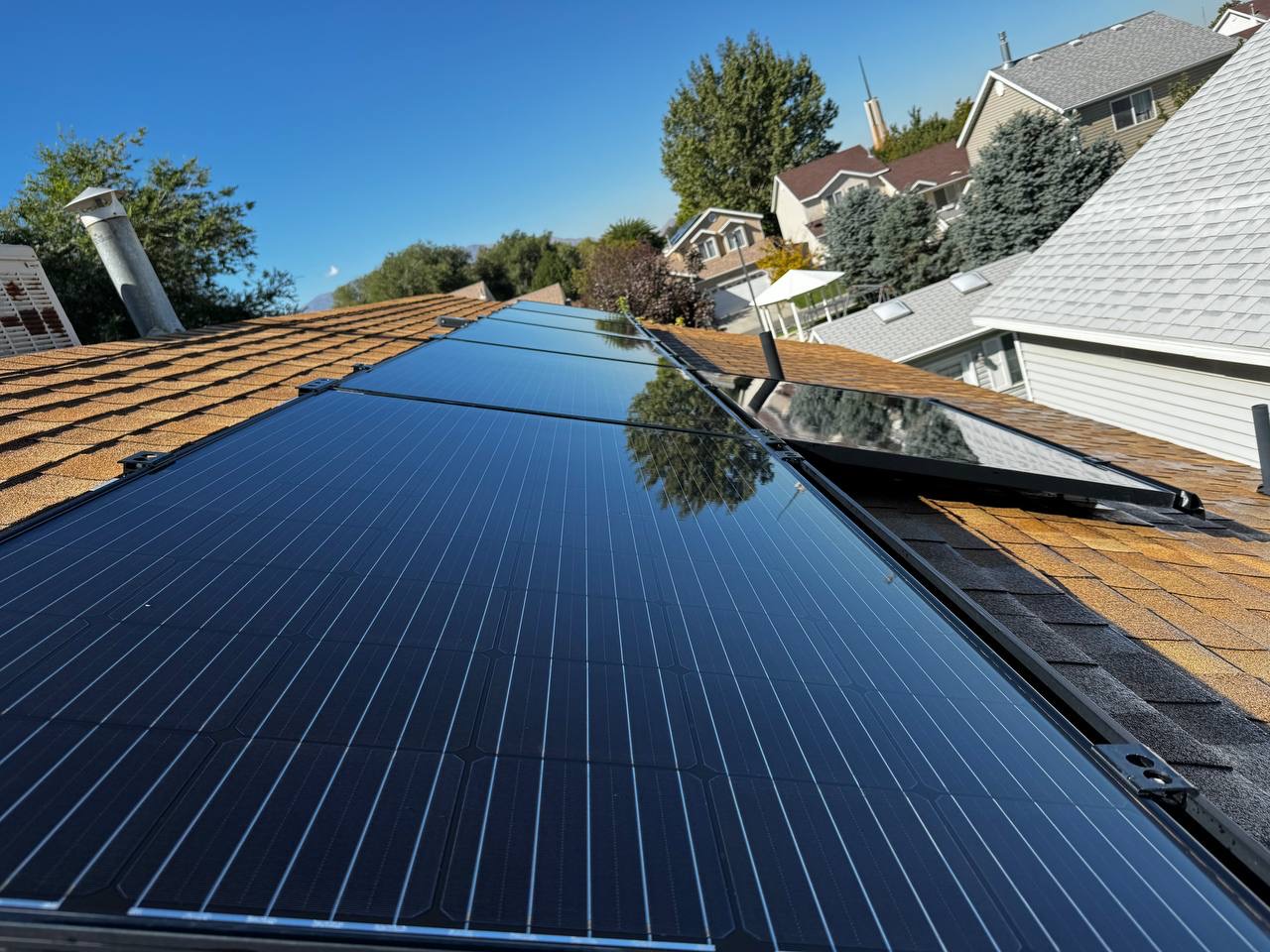 Low-angle view of clean black solar panels on a residential roof